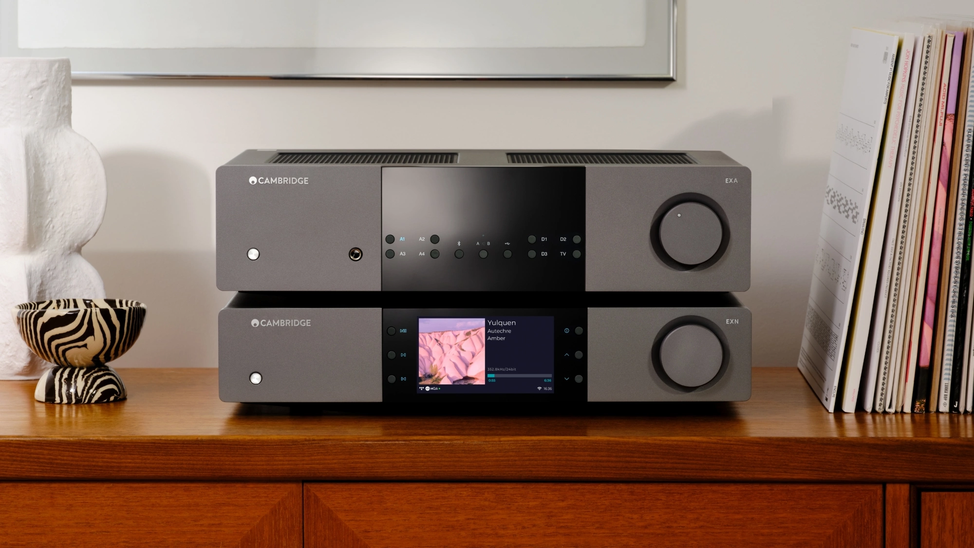 Hudební streamer a zesilovač Cambridge Audio na dřevěné skříni